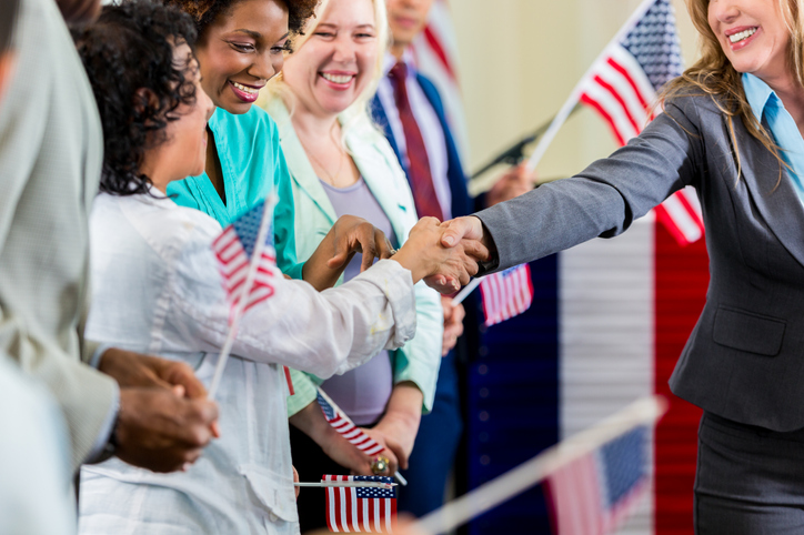 woman politician shaking hands with voters and connecting with voters. successful political campaign